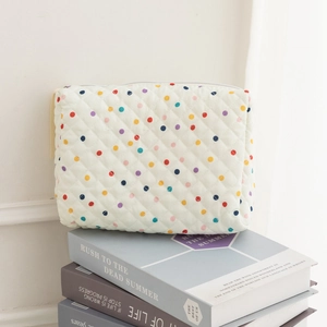 Detailed macro view of quilted cotton cosmetic bag with colorful polka dot pattern texture