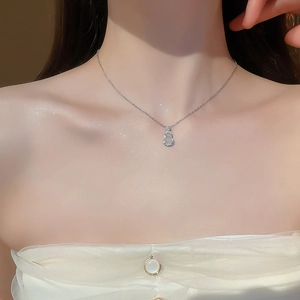 Gros plan d'un collier gourde en argent avec jade blanc et pavé de diamants brillants