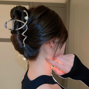 Silver metal cross wave hair claw with pearl shown on model in a stylish updo hairstyle