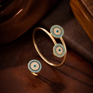 Macro detail of golden Evil Eye jewelry set with blue zircons on velvet background