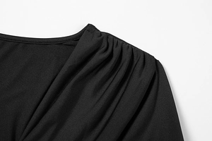 Detail of the elegant shoulder pleats and smooth fabric texture on this slim black dress