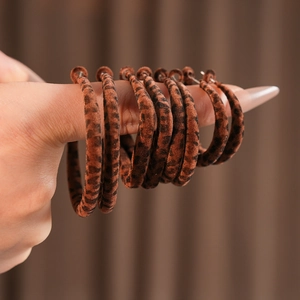 Gros plan de boucles d'oreilles créoles à imprimé léopard en velours marron