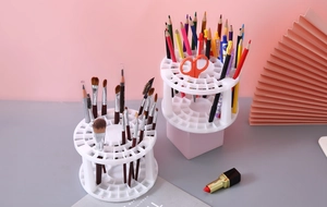 Macro detail of a white multi-slot holder organizing makeup brushes and color pencils