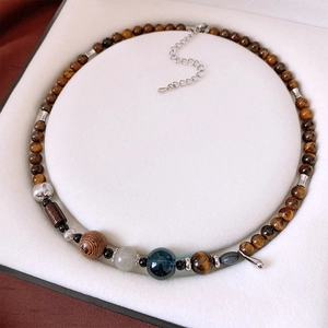 Macro detail of tiger eye stone and wooden beads on a vintage ethnic style necklace