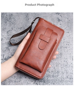 Handheld view of brown vintage leather wallet with phone pocket and wrist strap