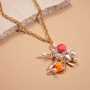 Detail of starfish and seashell pendant necklace with pearls on a golden chain