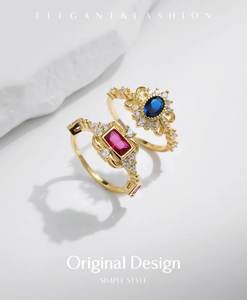 Detailed macro of gold rings with elegant red gemstone and blue oval sapphire accents