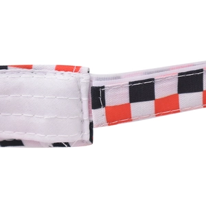 Detail of red and black checkered fabric strap with velcro closure on sun visor hat