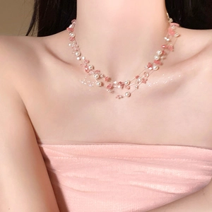 Close-up of pink crystal and pearl beaded layered necklace on a female collarbone