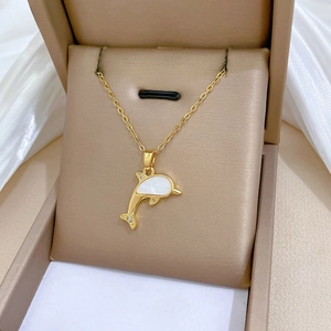 Detailed macro of a gold dolphin pendant with shell inlay and zircons in a jewelry box