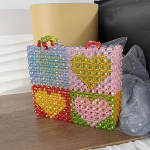 Macro shot of colorful beaded tote bag showing intricate heart patterns and acrylic pearls