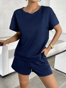 Detail of dark blue knit fabric texture on women's short sleeve top and shorts set