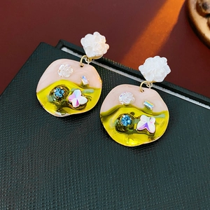 Detail of floral earrings with pink enamel, blue crystal and butterfly motif on black box