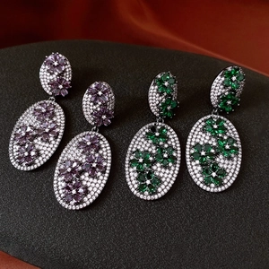 Detail view of vintage floral drop earrings with micro-set zircons in purple and green