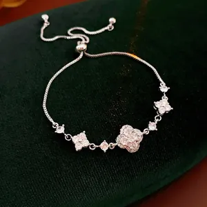 Elegant gold plated clover flower bracelet with sparkling cubic zirconia on green velvet