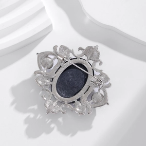 Broche camée vintage en argent ajouré avec centre ovale noir et épingle en métal
