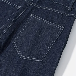 Gros plan détaillé de la poche arrière en denim bleu foncé avec surpiqûres blanches