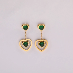 Detailed view of long heart earrings with green crystals and gold plated hollow frames