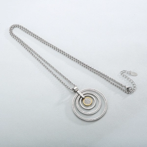 Detailed macro view of triple-circle concentric pendant with crystal pavé on silver chain