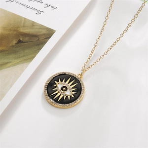 Detail of gold evil eye pendant with black enamel and micro-set zircon stones on chain