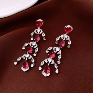 Detail of vintage silver heart earrings with red zircon tassels and crystal pavé accents