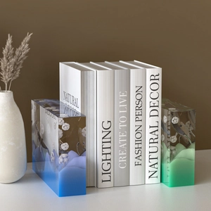 Detail dekorativer Buchstützen aus Harz mit Bergdesign und getrockneten Blumen