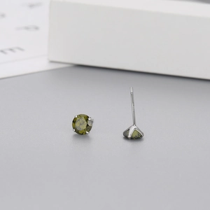 Close-up of S925 sterling silver stud earrings with olive green zircon in four-prong setting