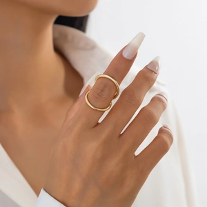 Dettaglio di anelli sottili dorati minimalisti indossati su mani di una modella