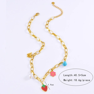 Close-up of strawberry and flower charms on a gold-tone stainless steel chain necklace