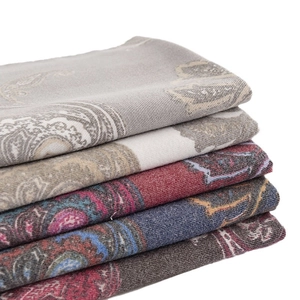 Stack of multicolored paisley pattern shawls in grey, beige, red, and blue fabrics