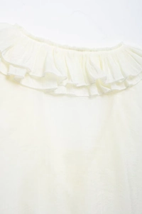 Close-up of the ruffled V-neckline with delicate white piping on a light chiffon blouse