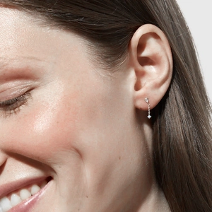 Detail of S925 silver chain earrings featuring drop zircon and blue opal on model