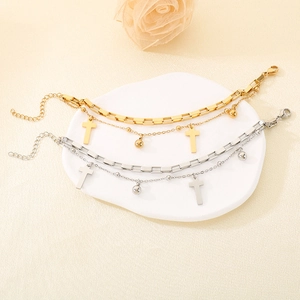 Detail view of 18K gold and silver double-layer cross bracelets with beads on a base