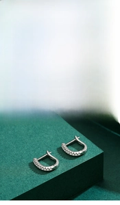 Macro detail of S925 sterling silver U-shaped hoop earrings with pave cubic zirconia