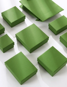 Lush grass green jewelry boxes and matching gift bags arranged on white background