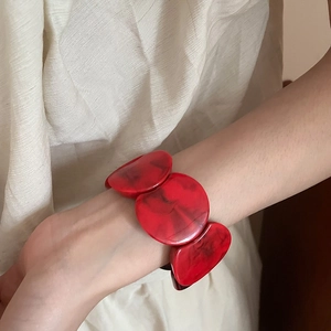 Close-up of red marble pattern acrylic bangle with bold round resin blocks for women