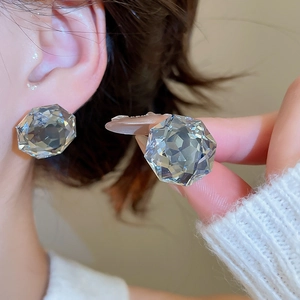 Close-up of elegant multifaceted crystal stud earrings with sterling silver needles