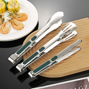 Set of 3 stainless steel food tongs with green silicone handles on a wooden board