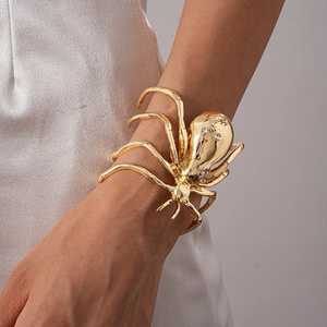 Close-up of golden spider-shaped bracelet with sparkling rhinestones on model's arm