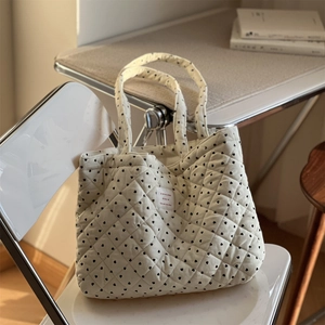 Gros plan du sac cabas en velours côtelé matelassé avec motifs de cœurs noirs