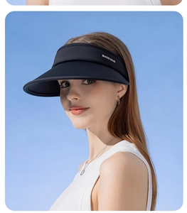 Close-up of black UPF50+ sun hat brim with white logo against a clear blue sky