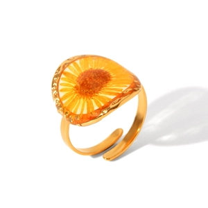Detail of adjustable gold stainless steel ring featuring a yellow dried daisy in resin