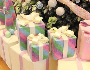 Dettaglio di scatole regalo di Natale colorate con trama intrecciata e grandi fiocchi
