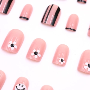Cute pink press-on nails featuring hand-drawn smiles and white floral patterns