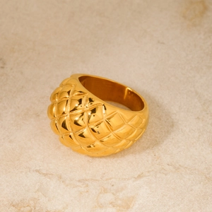 Dettaglio macro dell'anello in acciaio inossidabile oro 18k con incisione a rombi trapuntati