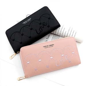 Detail of long zippered wallets with heart quilting and Love embroidery in black and pink