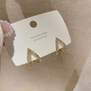 Detailed shot of gold V-shaped crystal earrings with 925 silver post displayed on card
