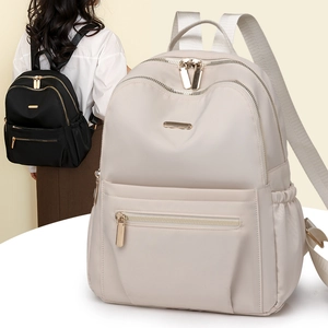 Detail showing high-quality nylon backpack with multiple zipper pockets and smooth metal parts