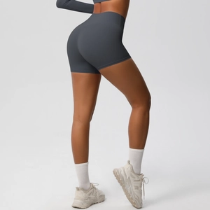 Detail view of high waisted dark gray yoga shorts with peach hip lifting and matte fabric