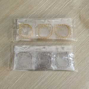 Detailed view of elastic gold and silver beaded bracelets in clear plastic packaging